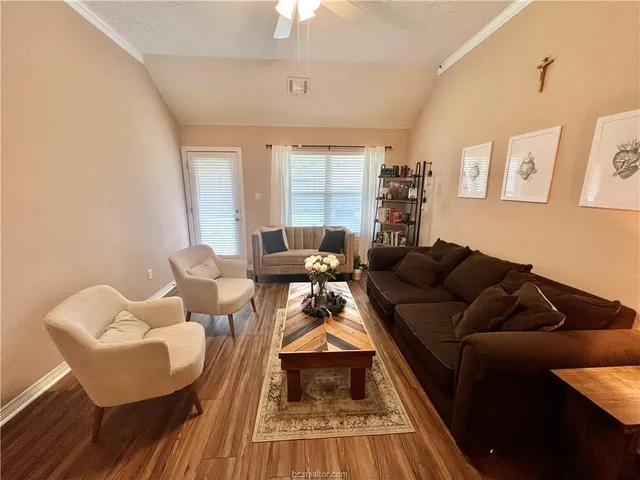 a living room with furniture and a wooden floor