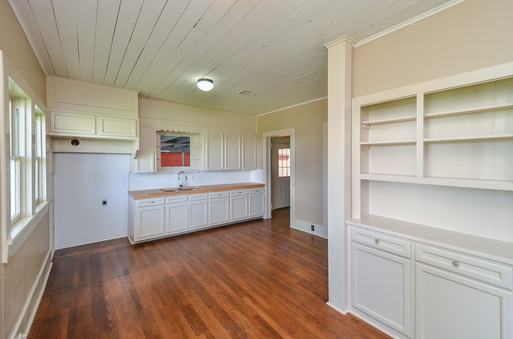 404 West Main Street Bellville, TX 77418 - Photo 11 of 25 a kitchen with wooden floors and wooden cabinets