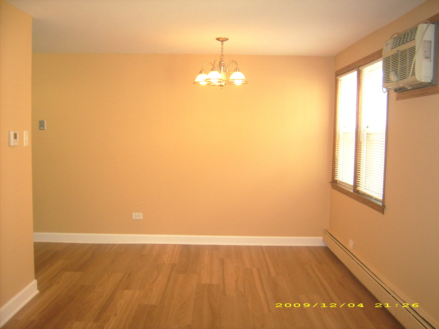 7019 West Irving Park Road, Unit 2 Chicago, IL 60634 - Photo 5 of 14 an empty room with wooden floor and windows