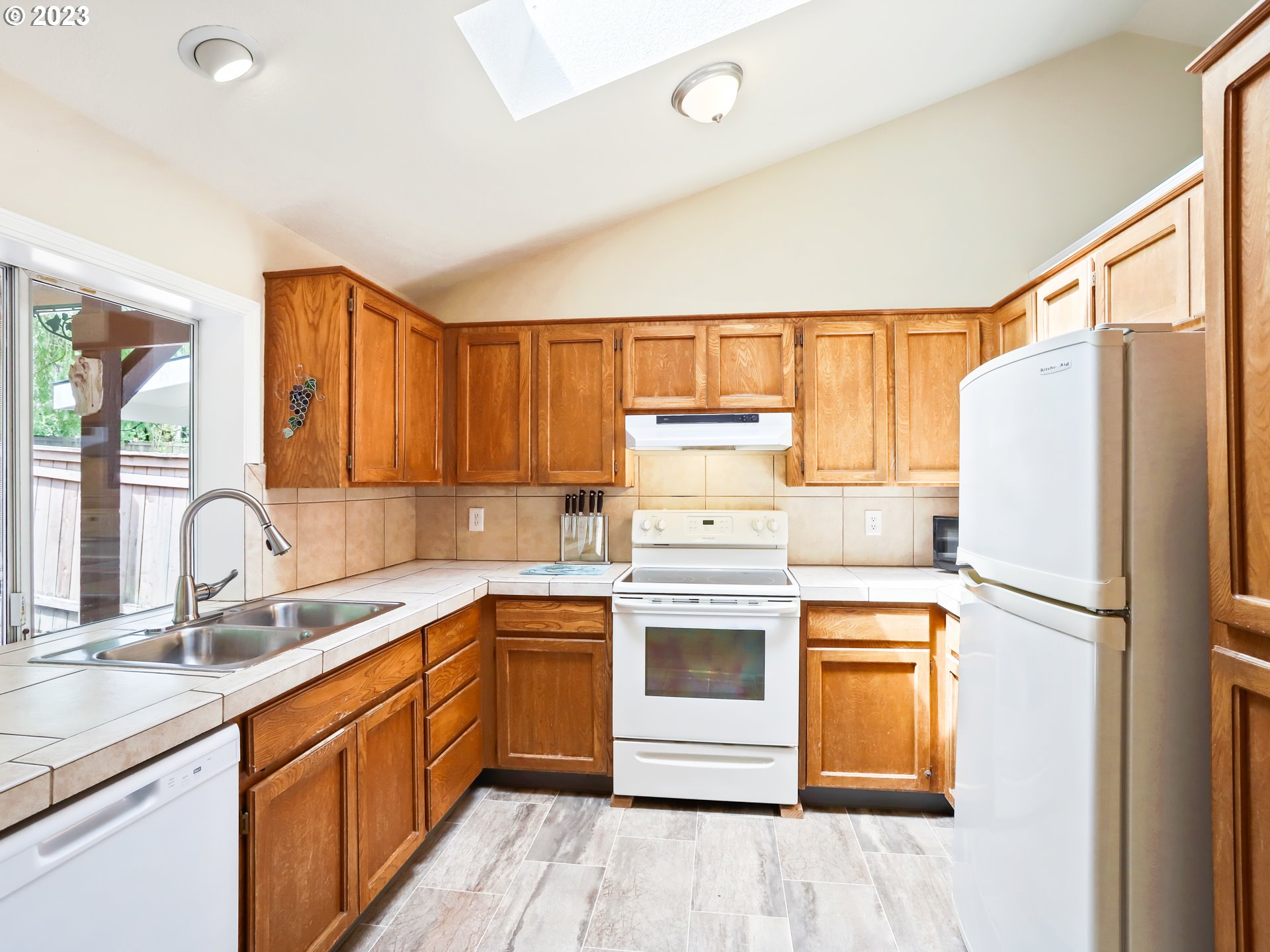 13224 Southwest Shore Drive Portland, OR 97223 - Photo 11 of 30 a kitchen with a sink cabinets stainless steel appliances and a window