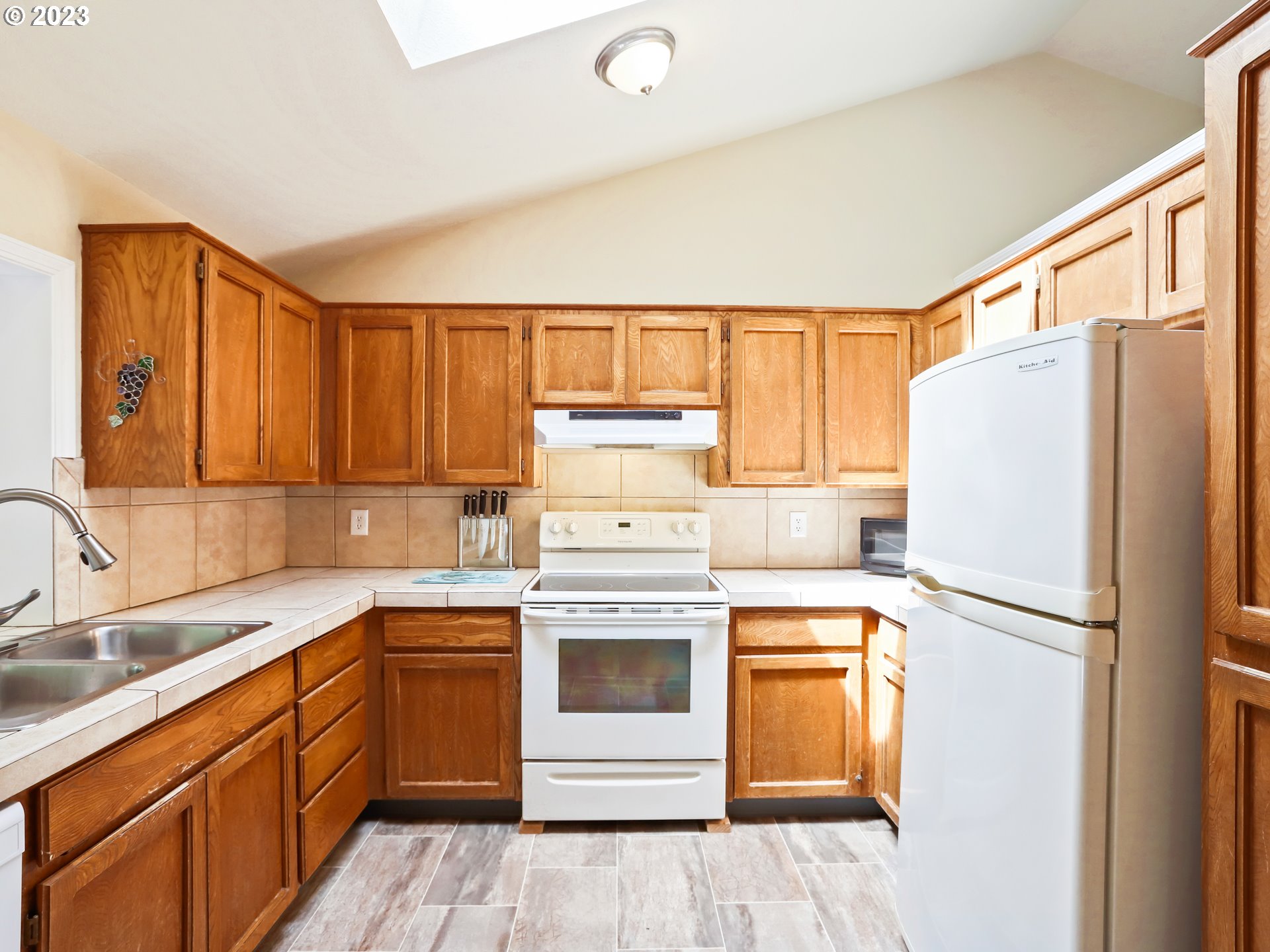 13224 Southwest Shore Drive Portland, OR 97223 - Photo 12 of 30 a kitchen with a refrigerator sink and cabinets