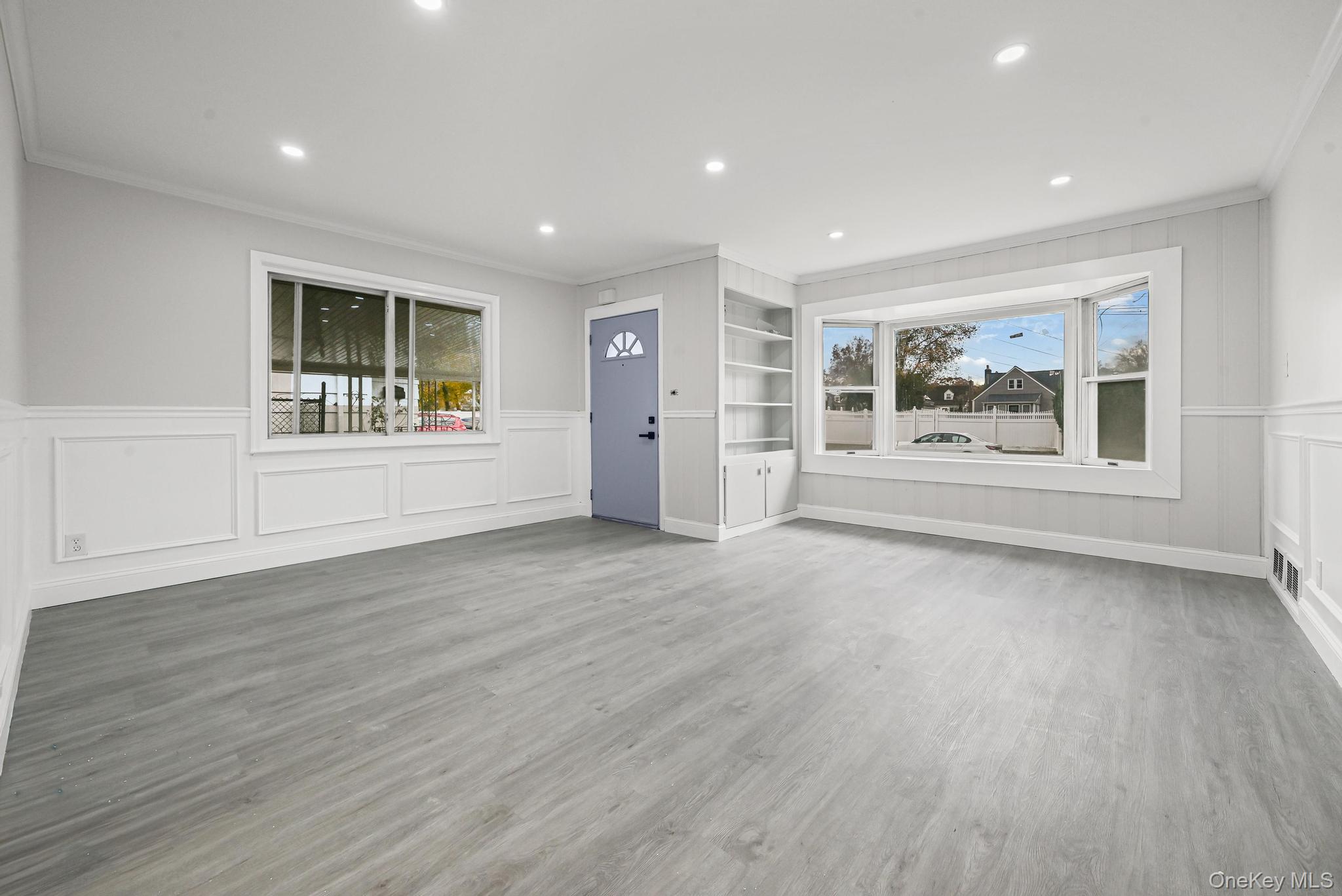 312 Coventry Road South West Hempstead, NY 11552 - Photo 12 of 30 Empty room with ornamental molding, light wood finished floors, a decorative wall, healthy amount of natural light, and recessed lighting