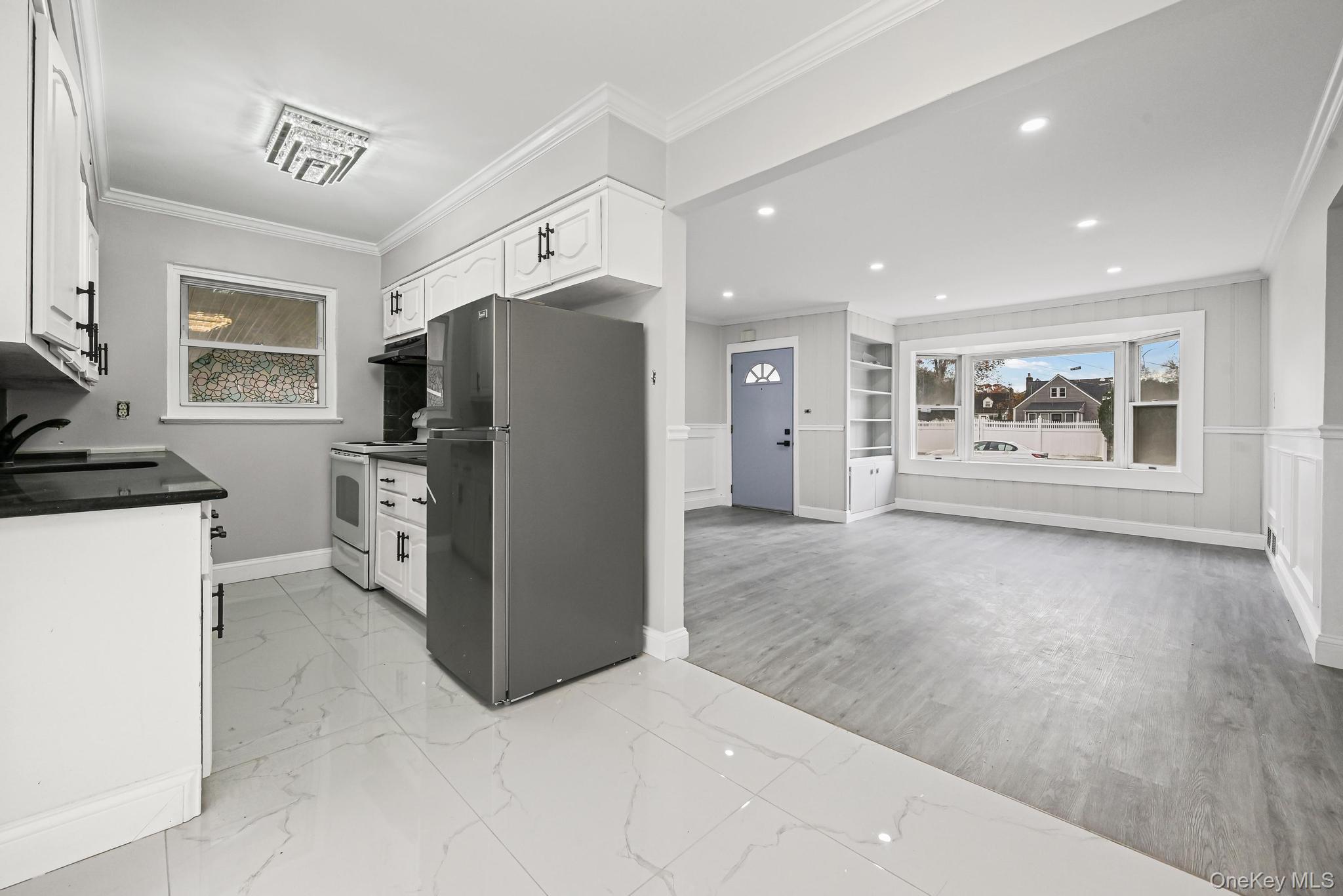 312 Coventry Road South West Hempstead, NY 11552 - Photo 17 of 30 Kitchen featuring freestanding refrigerator, crown molding, white cabinets, electric range, and dark countertops