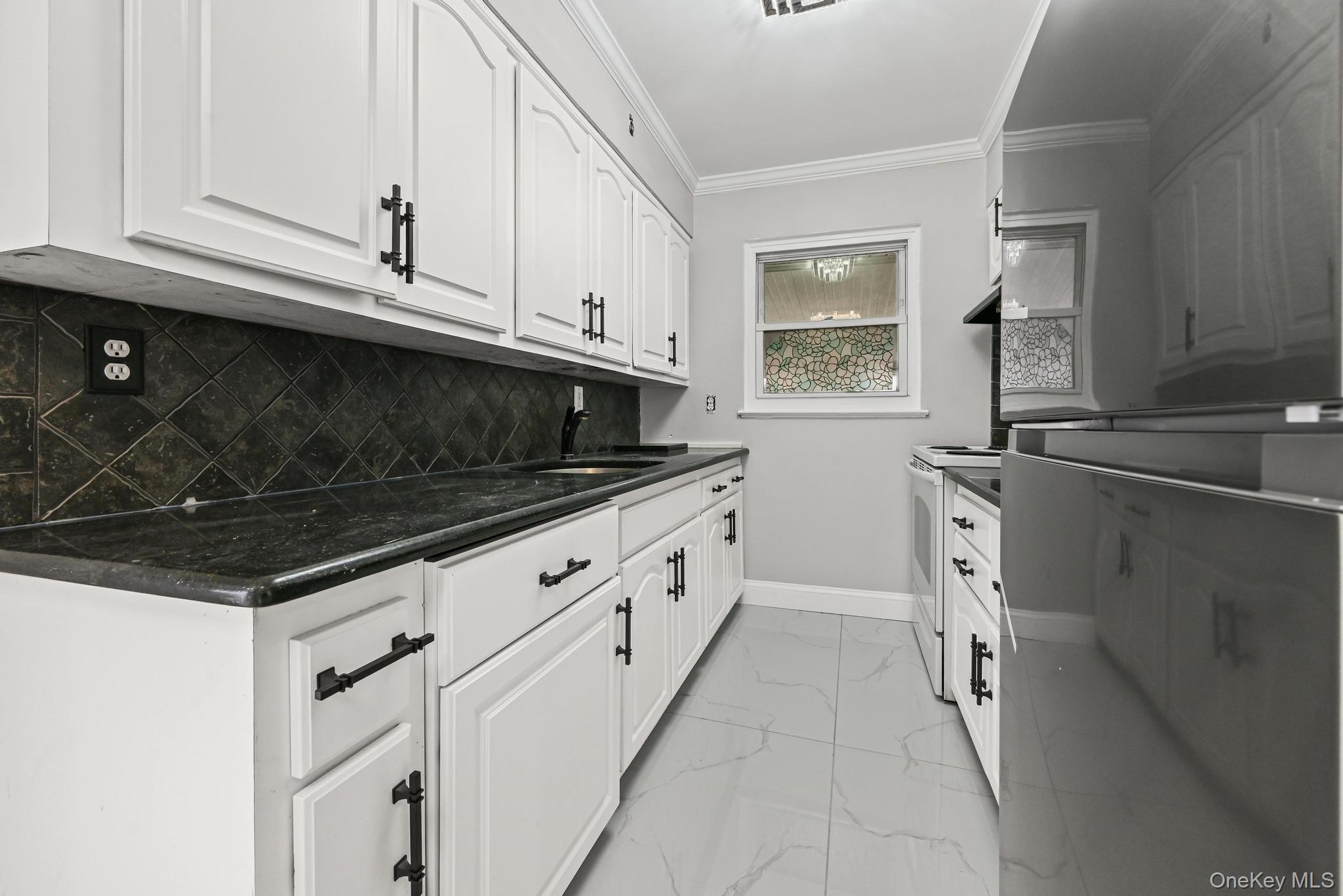 312 Coventry Road South West Hempstead, NY 11552 - Photo 18 of 30 Kitchen with white range with electric stovetop, ornamental molding, light marble finish flooring, white cabinets, and backsplash