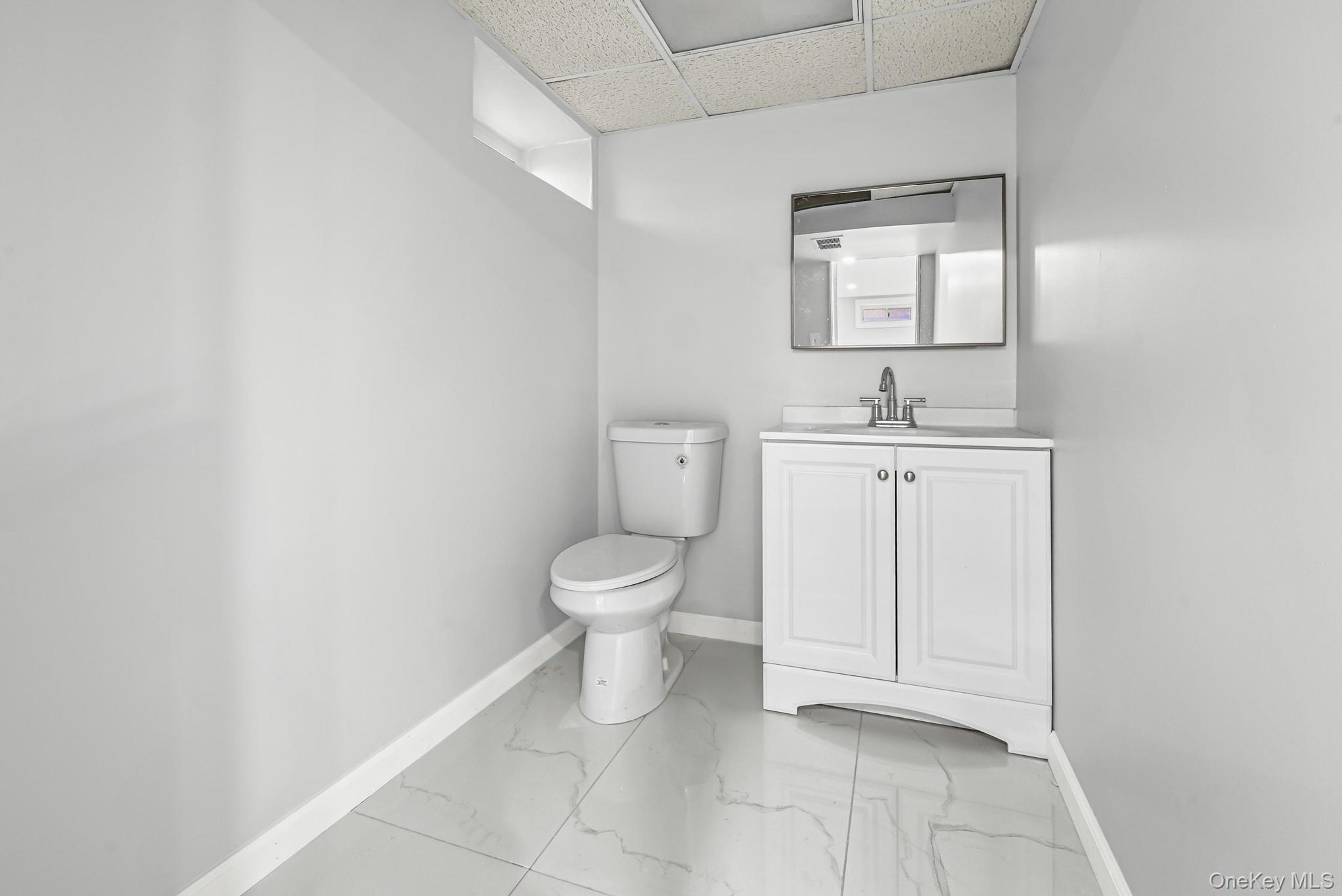 312 Coventry Road South West Hempstead, NY 11552 - Photo 28 of 30 Bathroom with a drop ceiling, vanity, and light marble finish floors