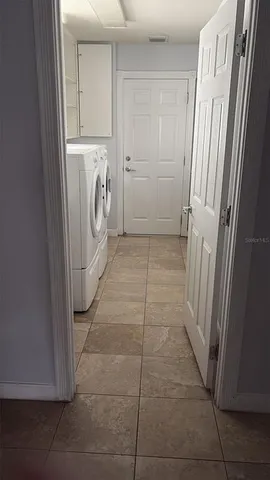 a view of a storage and utility room with washer and dryer