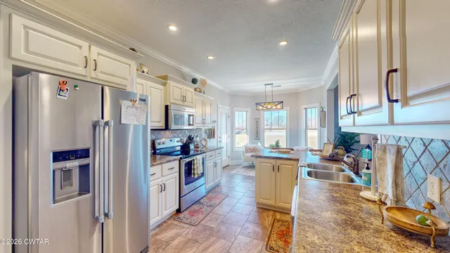 a kitchen with stainless steel appliances granite countertop a refrigerator and a stove top oven