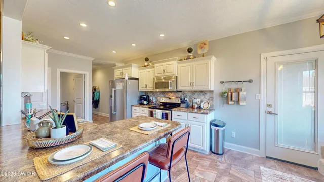 a kitchen with kitchen island stainless steel appliances a sink and cabinets