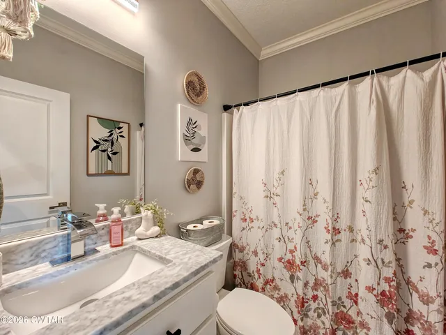 a bathroom with a granite countertop sink a toilet and a mirror