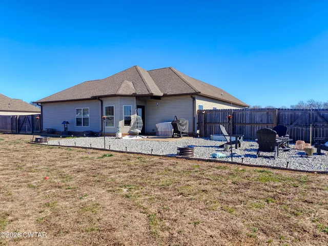 a front view of house with yard and trees in the background