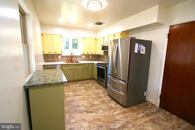 a kitchen with stainless steel appliances granite countertop a refrigerator and a stove