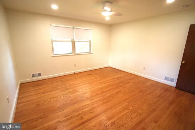 a view of empty room with wooden floor