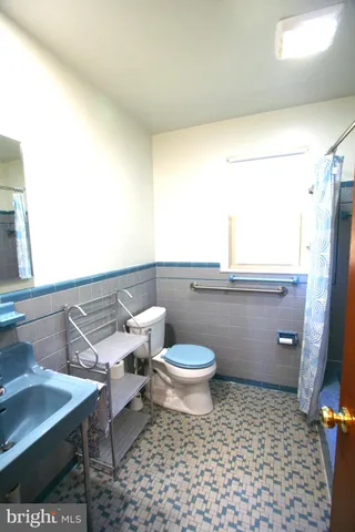 a bathroom with a toilet a sink and a window