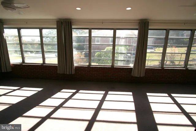 a view of a refrigerator in kitchen and an empty room