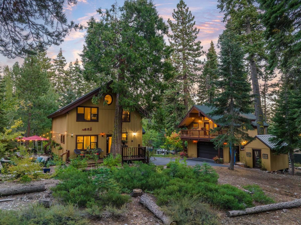 a front view of a house with a yard and tree s