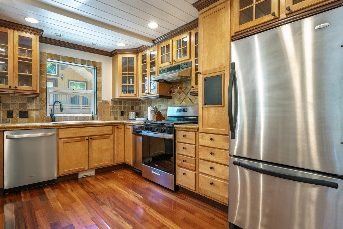 4465 North Ridge Road Carnelian Bay, CA 96140 - Photo 4 of 28 a kitchen with stainless steel appliances a refrigerator sink and cabinets