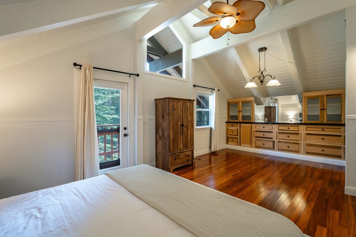 4465 North Ridge Road Carnelian Bay, CA 96140 - Photo 7 of 28 a spacious bedroom with a bed and a chandelier