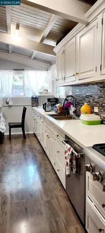 a close view of stove kitchen with granite countertop white cabinets and a stove