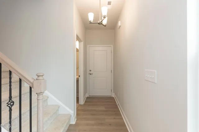 a view of a hallway with wooden floor and staircase