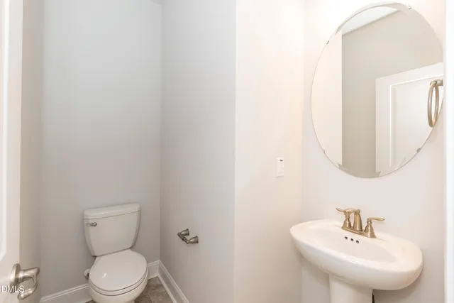 an empty room with wooden floor fireplace and windows
