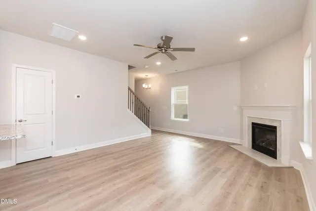 an empty room with windows and fireplace