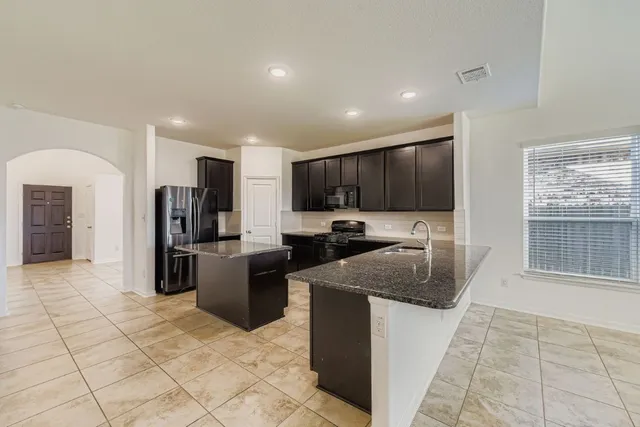 a kitchen with stainless steel appliances granite countertop a refrigerator and a sink