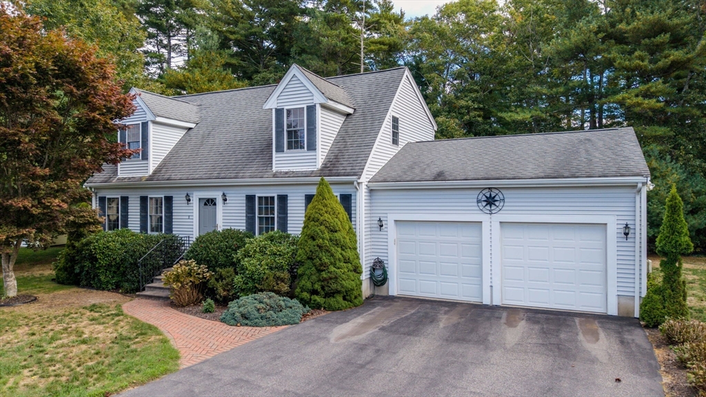 front view of house with a yard and potted plants