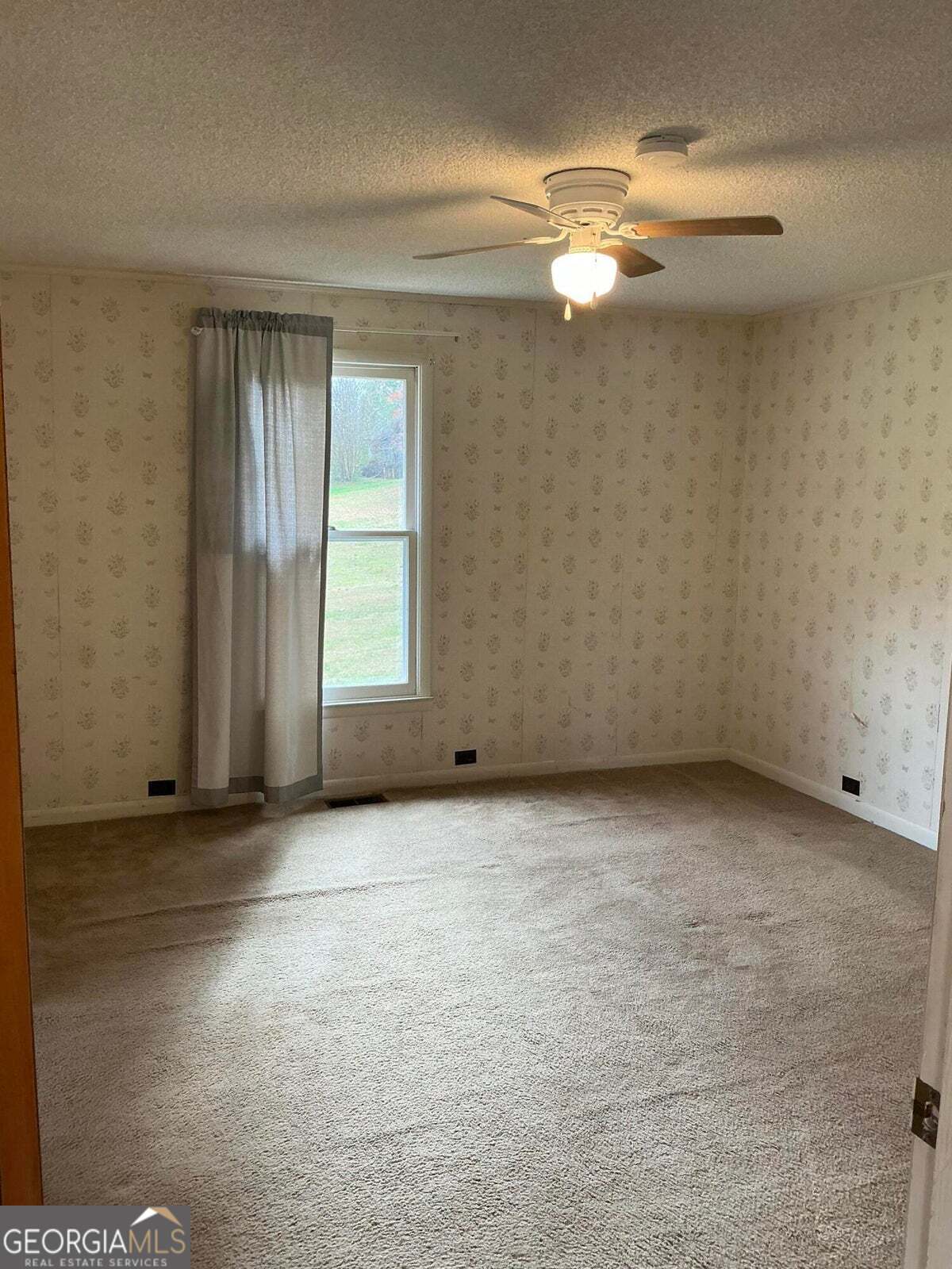 5062 B Highway Rock Spring, GA 30739 - Photo 4 of 19 an empty room with a chandelier fan and windows