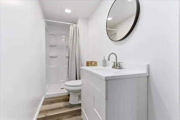 a bathroom with a sink toilet and a mirror
