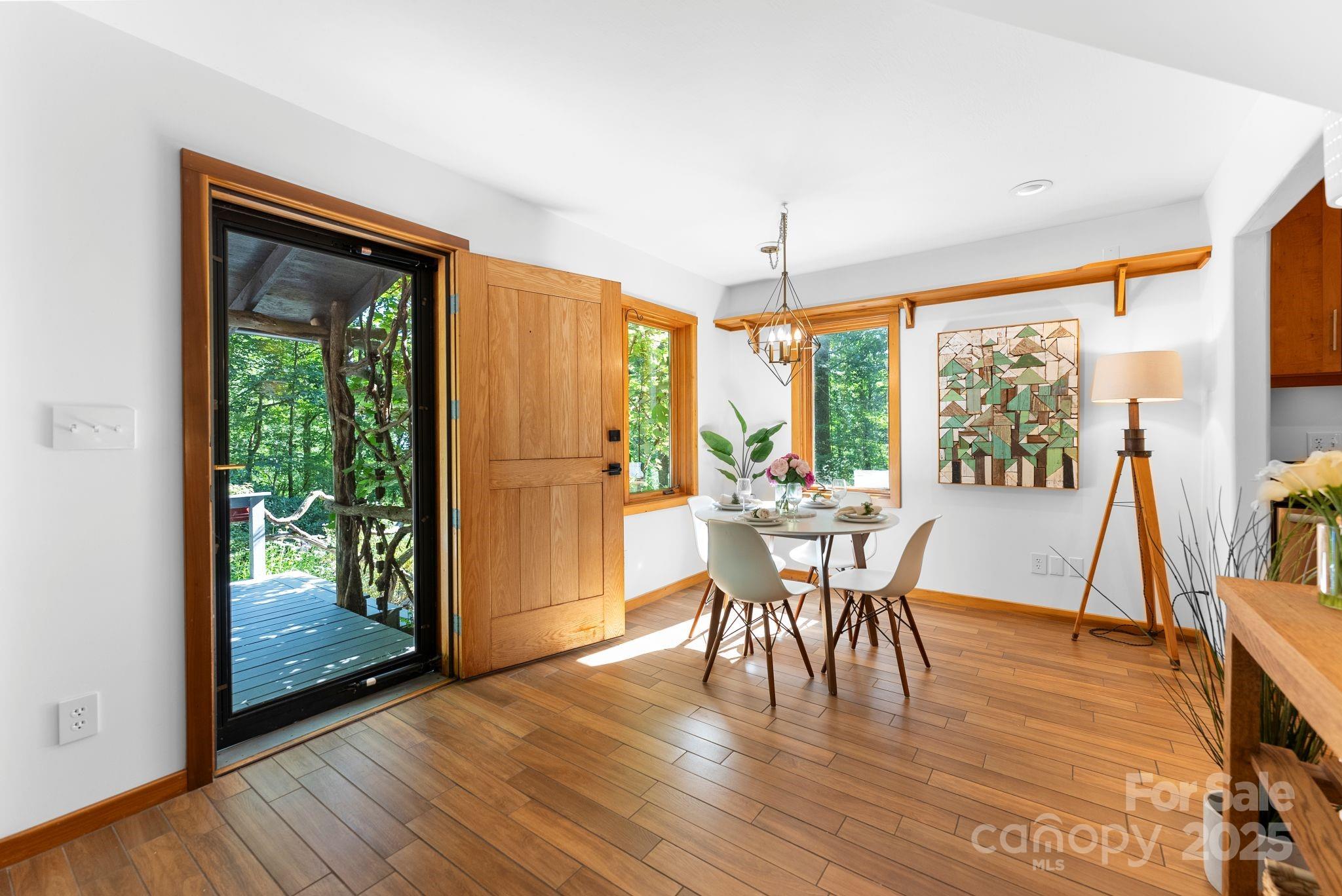 48 Black Oak Forest Road Fairview, NC 28730 - Photo 17 of 48 a dining room with wooden floor a chandelier a glass table and chairs