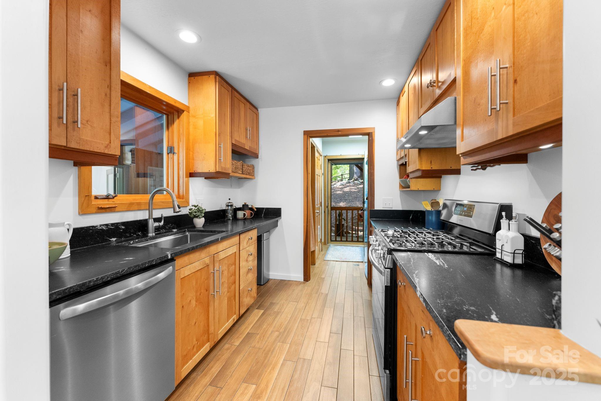 48 Black Oak Forest Road Fairview, NC 28730 - Photo 20 of 48 a kitchen with stainless steel appliances granite countertop a stove a sink and a microwave
