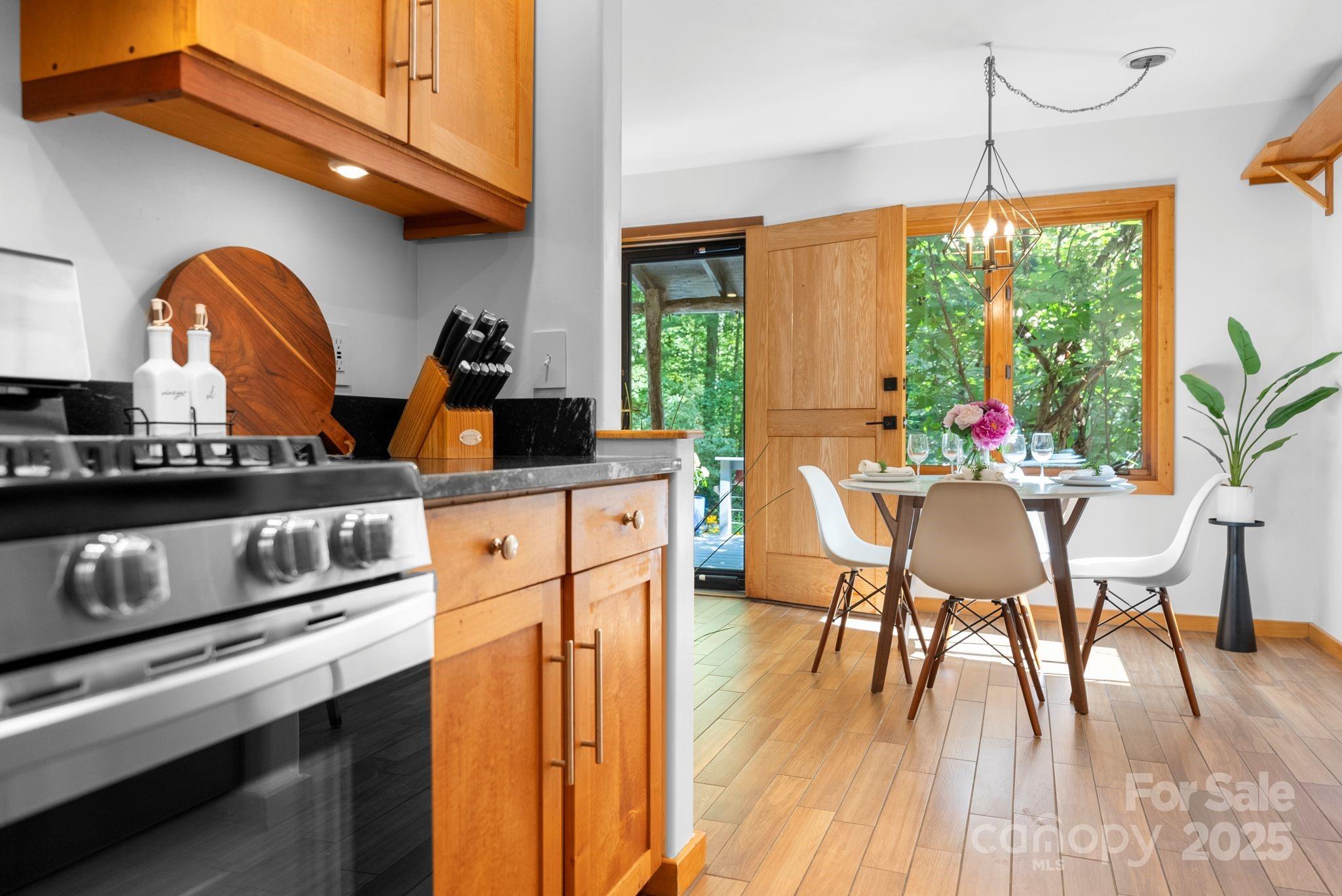 48 Black Oak Forest Road Fairview, NC 28730 - Photo 21 of 48 a kitchen with stainless steel appliances granite countertop a stove a refrigerator a kitchen island with a dining table and chairs