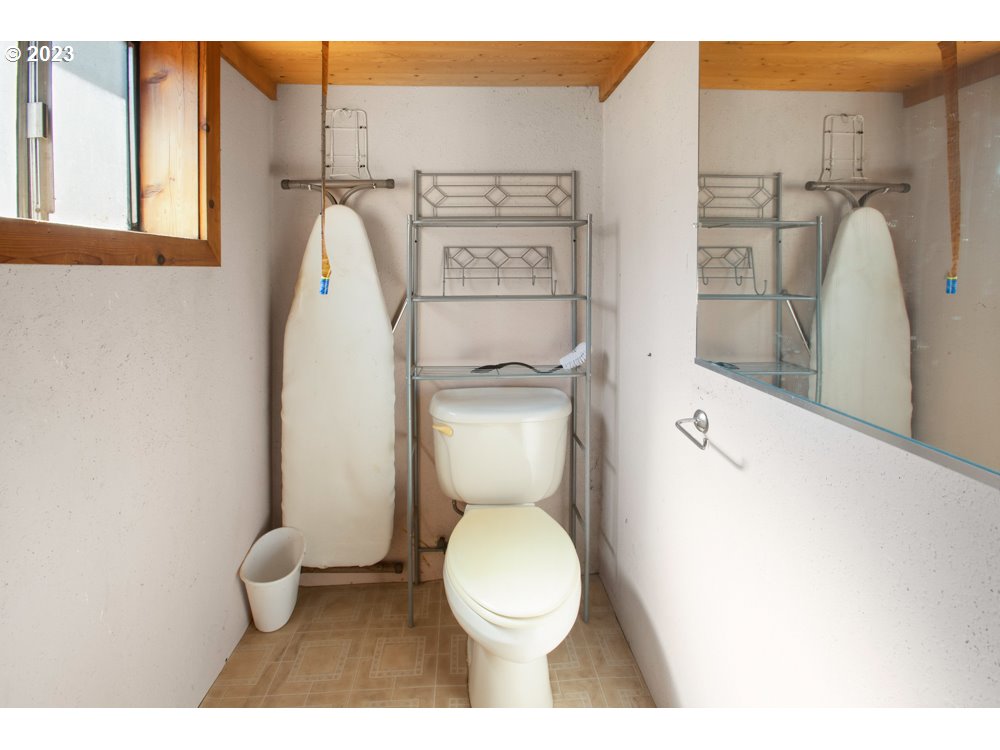 890 Crowfoot Road Eagle Point, OR 97524 - Photo 36 of 48 a white toilet sitting next to a bathroom sink and a mirror