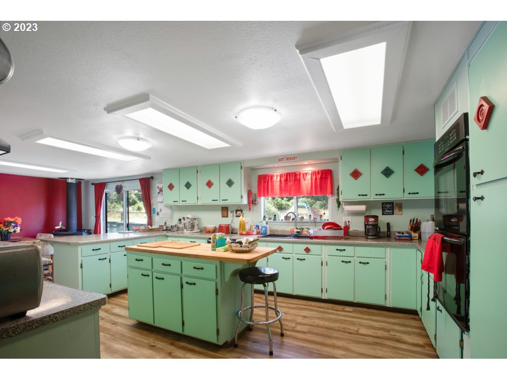 890 Crowfoot Road Eagle Point, OR 97524 - Photo 48 of 48 a room with kitchen island a sink wooden floor and a window