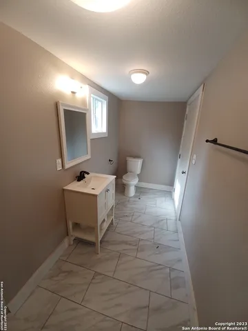 a view of a hallway with bathroom and a mirror