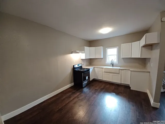 a kitchen with wooden floors and white appliances