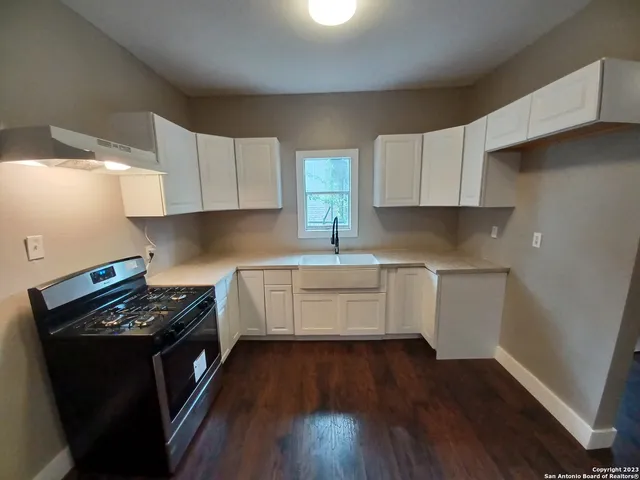 a kitchen with a sink a stove and cabinets