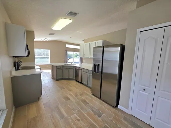 a kitchen with granite countertop a refrigerator and a sink