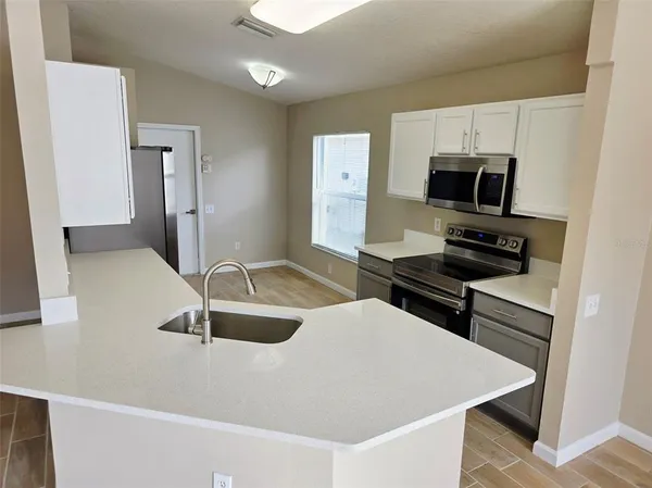 a kitchen with a sink a stove and microwave