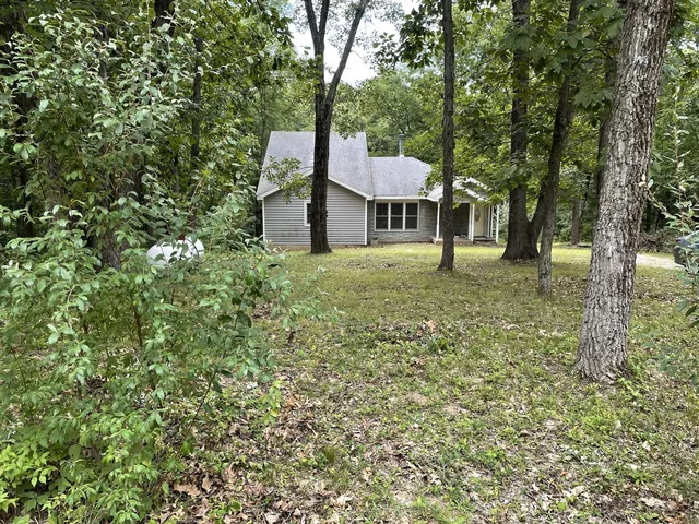 a yellow house in middle of the forest