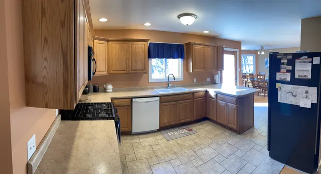 a large kitchen with stainless steel appliances a sink a stove and a refrigerator
