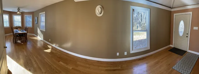 a view of a hallway with wooden floor and staircase