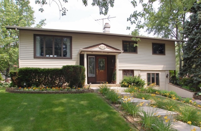 a front view of a house with a garden and plants