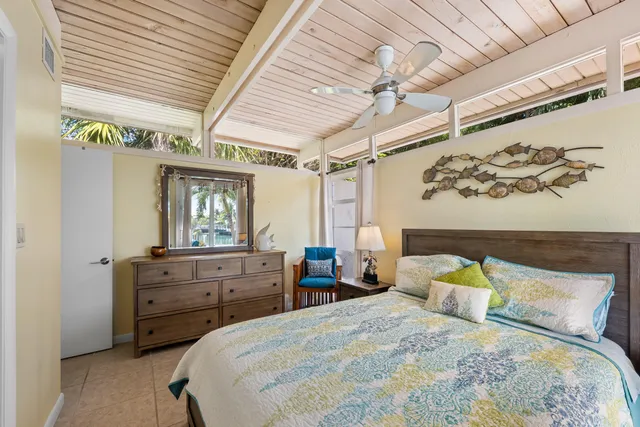 a bedroom with a bed a dresser and a large window