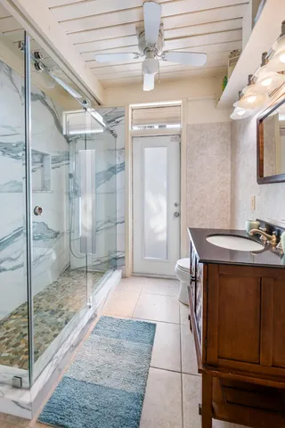 a spacious bathroom with a sink a toilet a mirror and shower