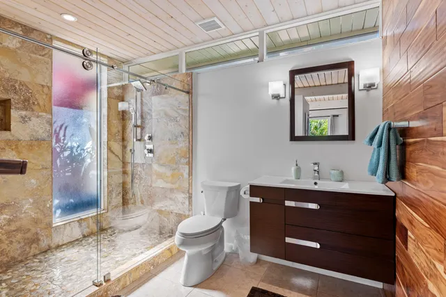 a bedroom with a bed and large windows