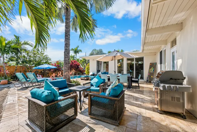 an outdoor sitting area with furniture and umbrella