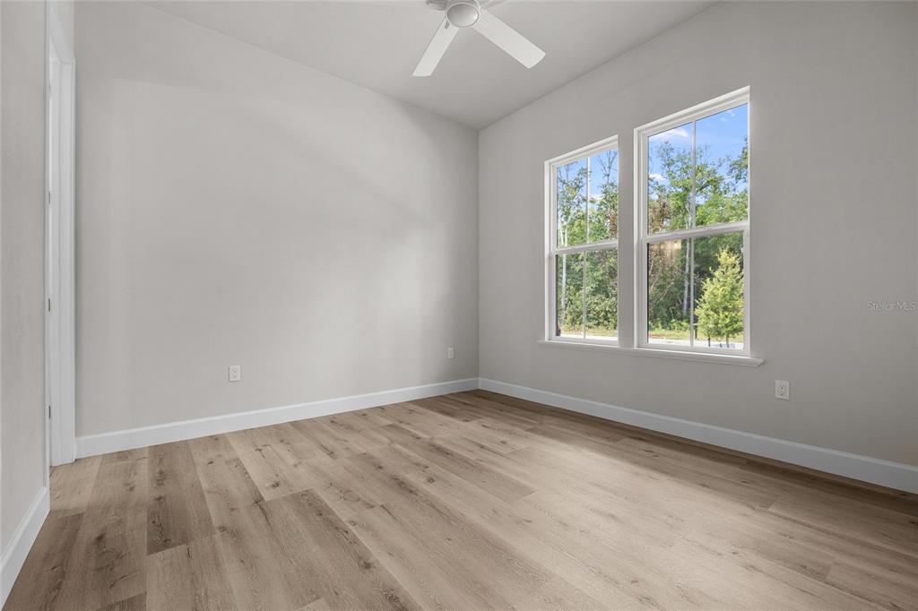 13425 Southwest 9th Road Newberry, FL 32669 - Photo 14 of 37 a view of an empty room with wooden floor and a window