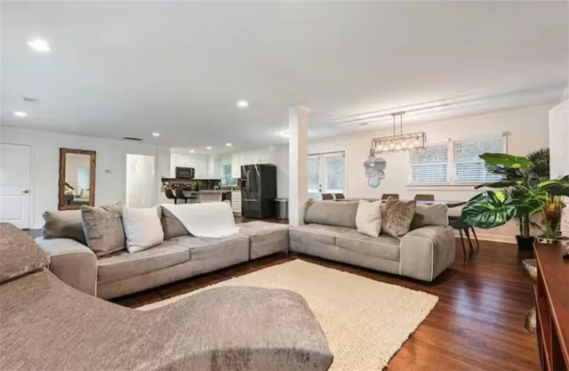 a kitchen with granite countertop stainless steel appliances a refrigerator a stove a sink a dining table and chairs