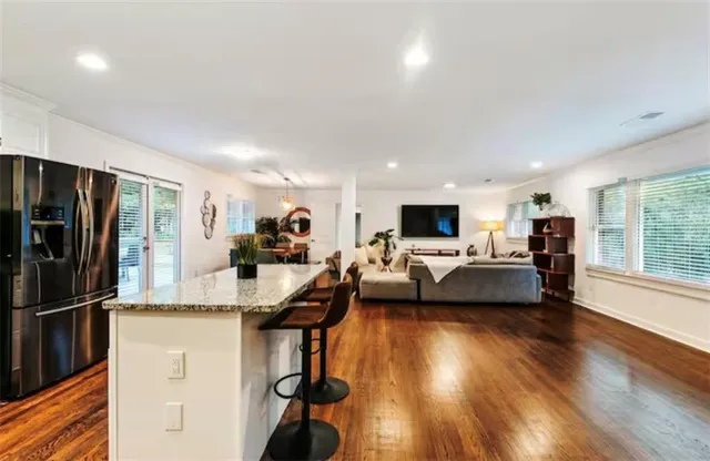 a living room with furniture a clock on wall and a window